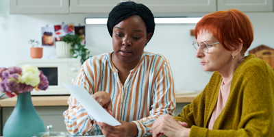 a person helping an elderly person with some paperwork
